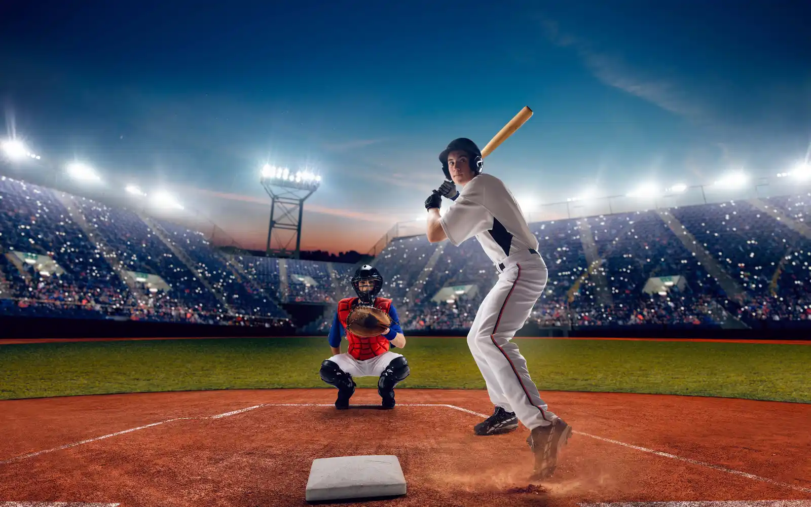 Batter and catcher at home plate during an evening game that could go to extra innings