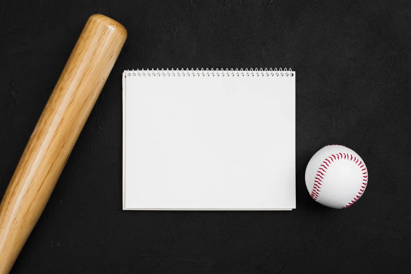 Notebook with a baseball and bat for tracking OPS in baseball